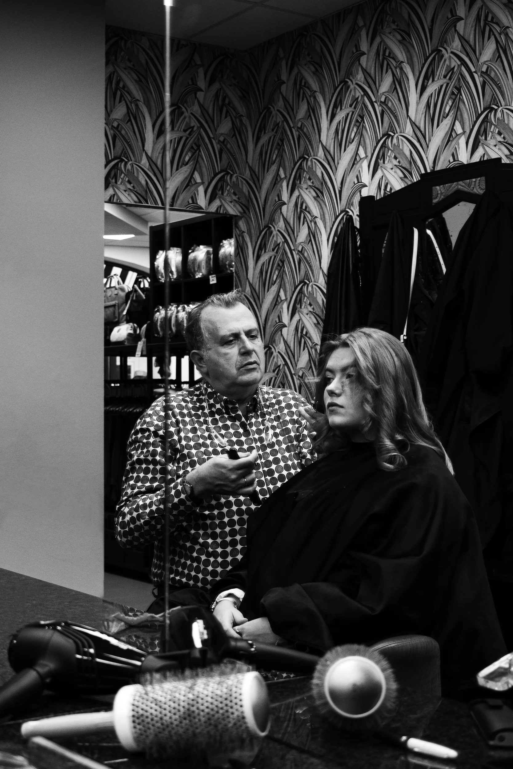 Coiffeur devant un miroir avec une cliente