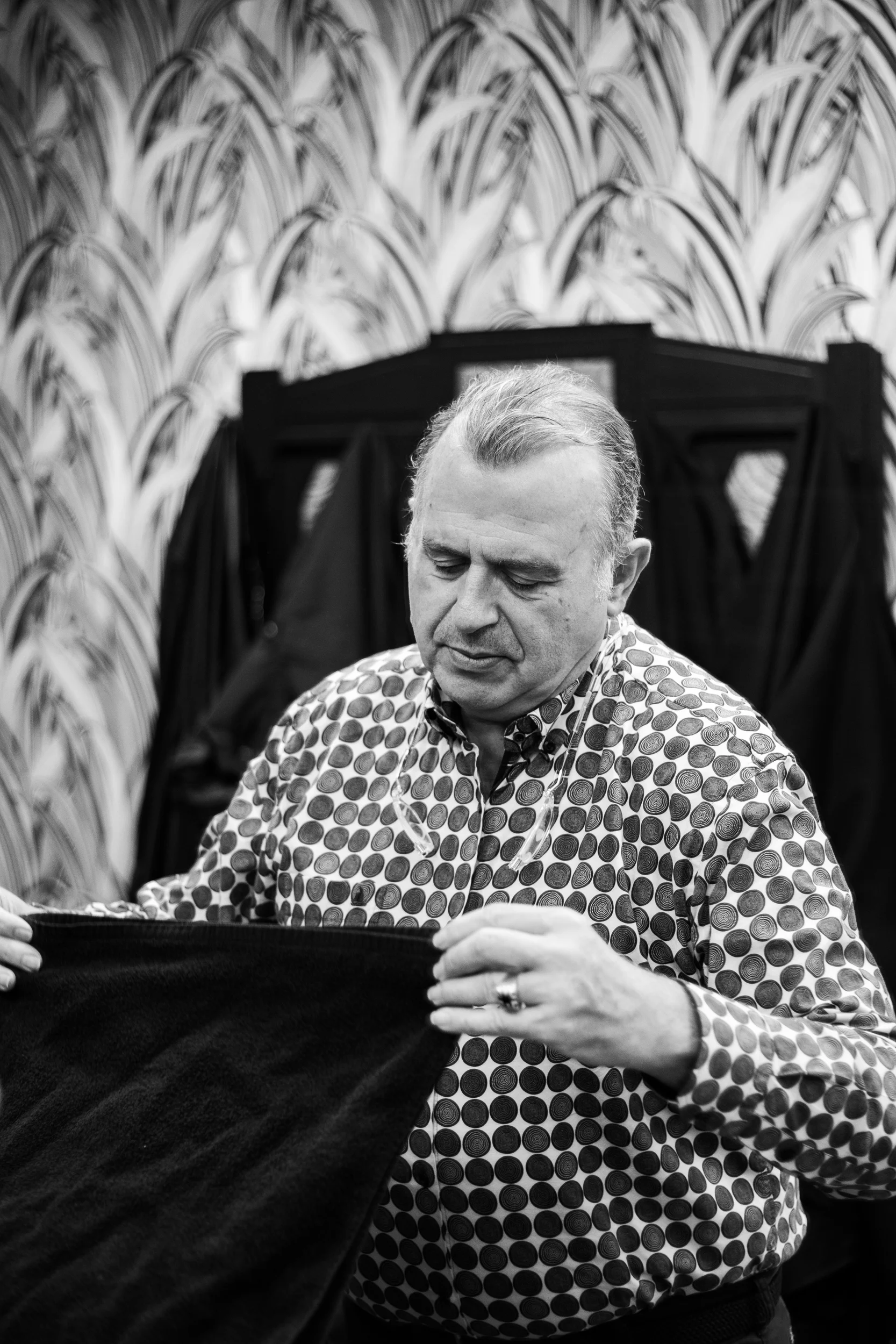 Yves Groise repliant une essuie dans son salon de coiffure
