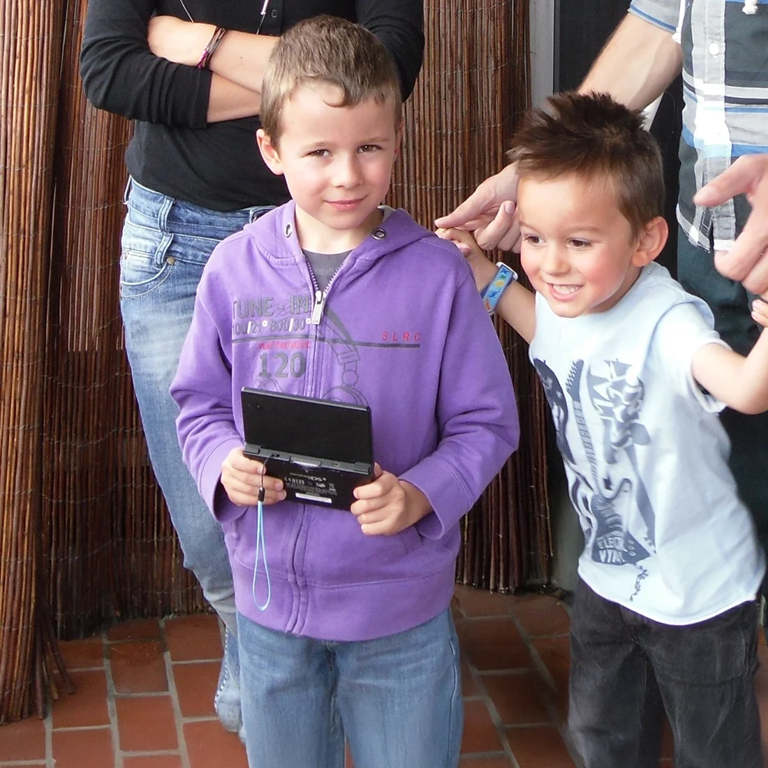 Iseox avec sa nintendo ds à la main pour prendre des photos